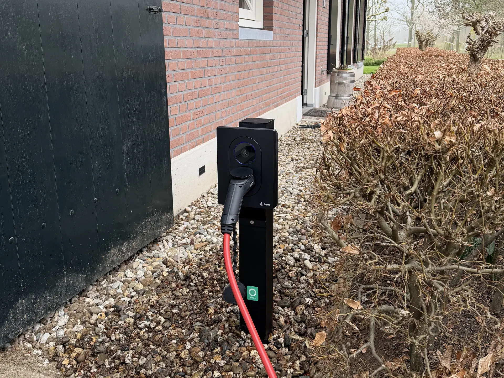 Vrijstaande montage op een paal, direct naast de parkeerruimte.