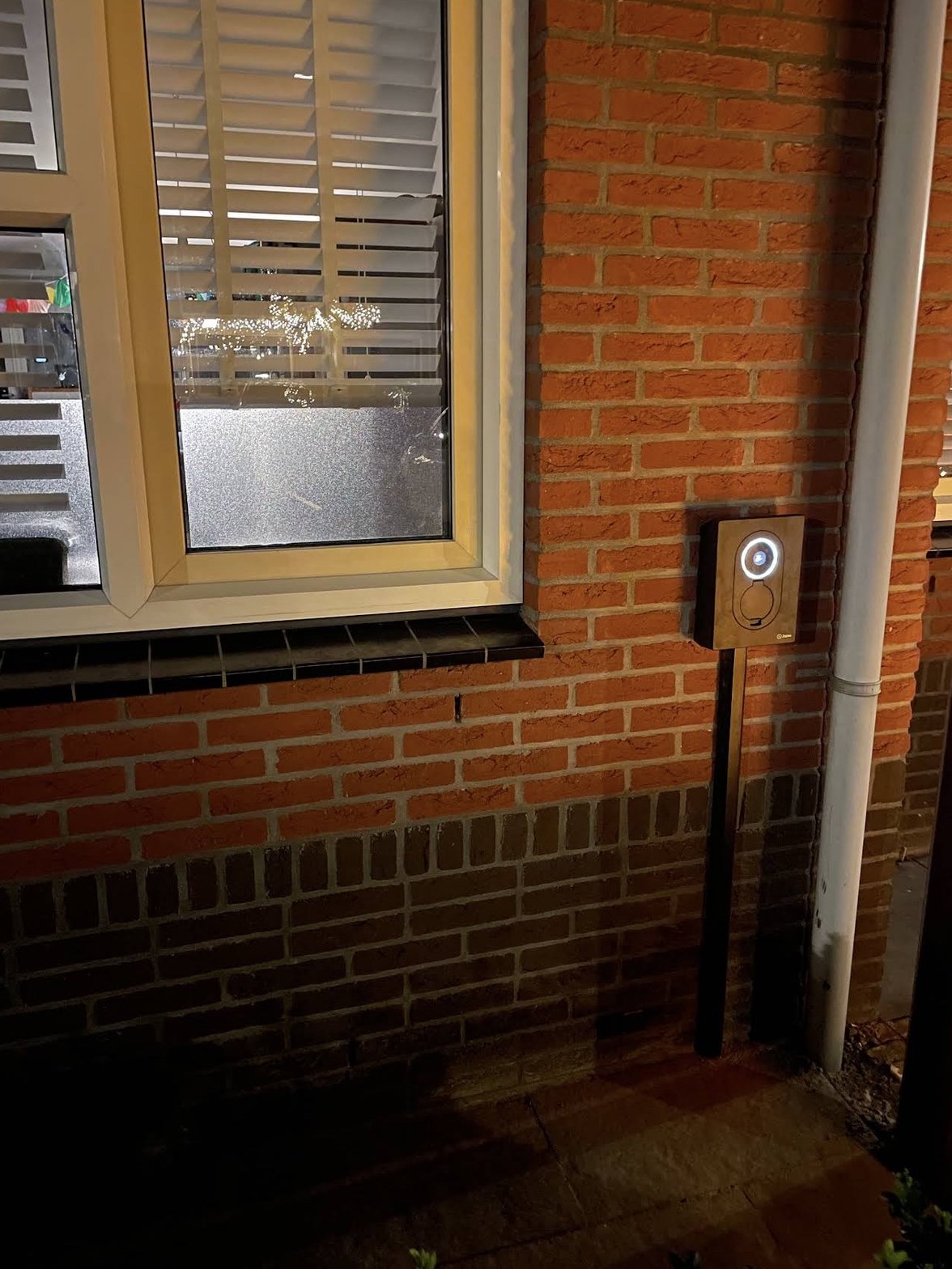 Zaptec Go laadpaal bij woning in avondlicht